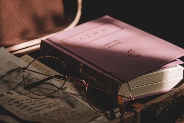 book, glasses, newspaper, retro. Literary coverage forms compared: review, essay, profile and report