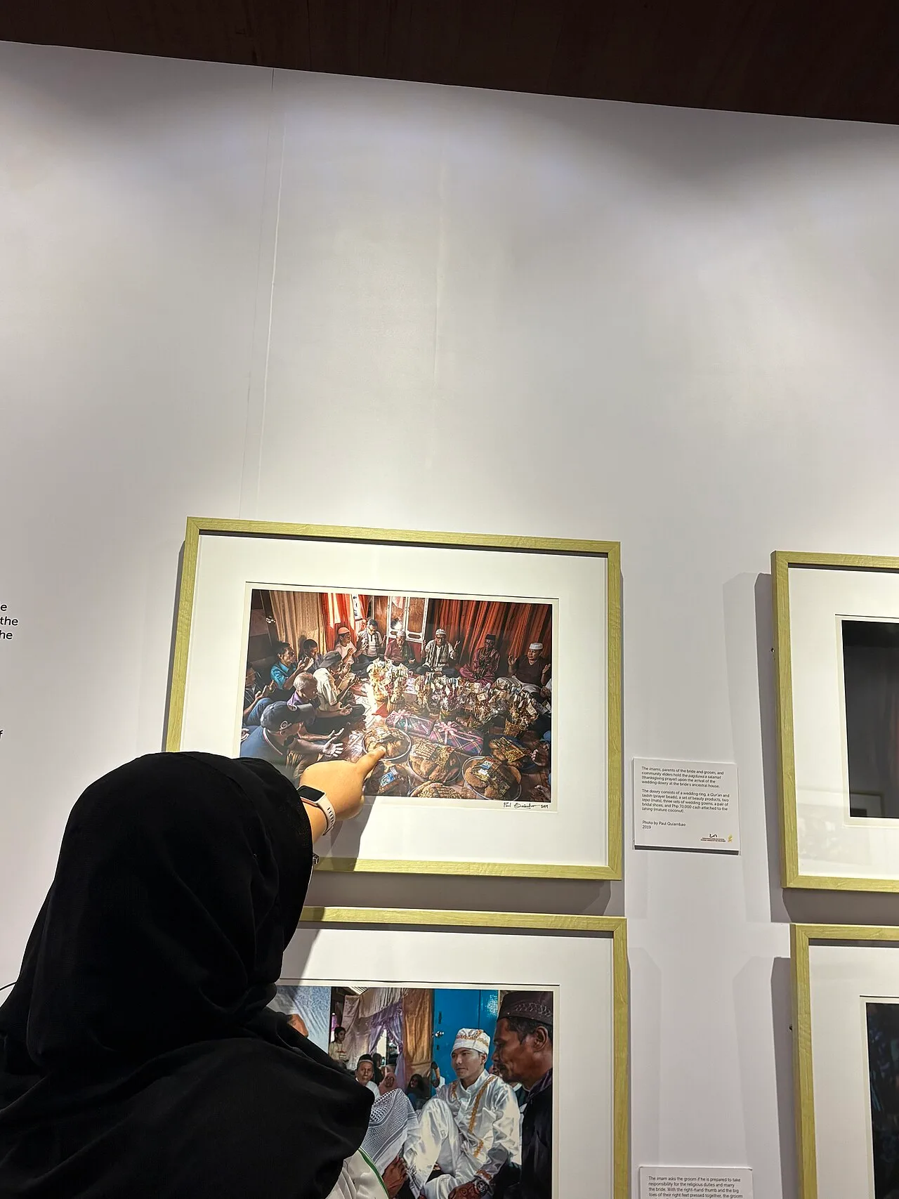 A visitor looking at a framed photograph in a museum exhibition