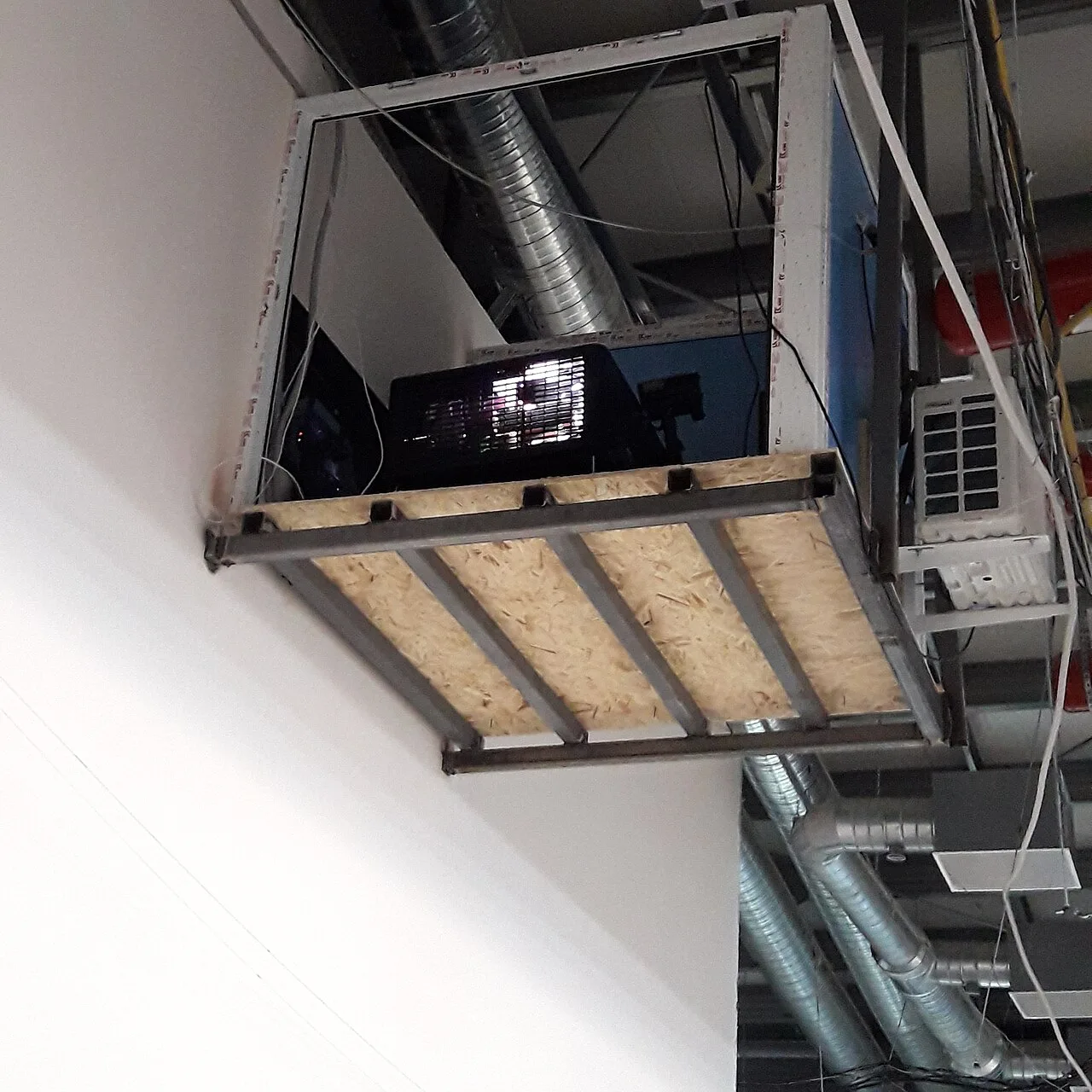A digital cinema projector mounted high inside a projection enclosure